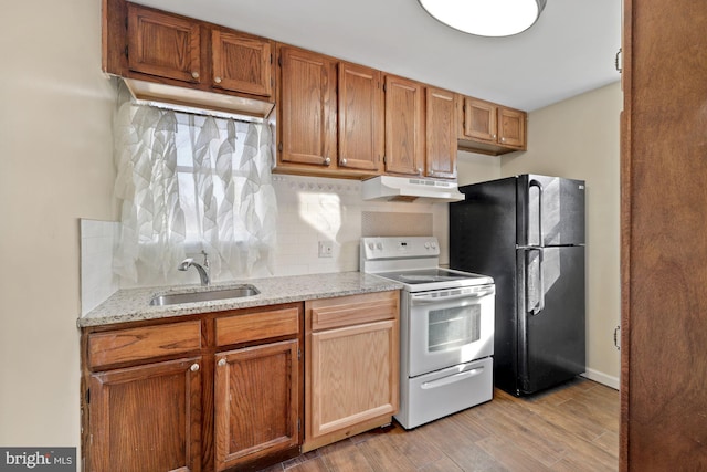 kitchen featuring light hardwood / wood-style floors, electric range, sink, decorative backsplash, and black refrigerator