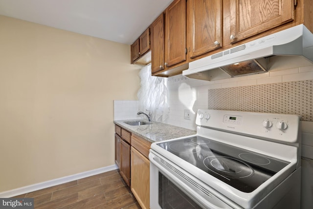 kitchen with light stone counters, backsplash, white range with electric stovetop, dark hardwood / wood-style floors, and sink