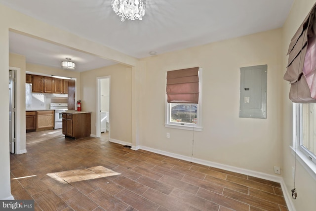 unfurnished living room with electric panel and a chandelier