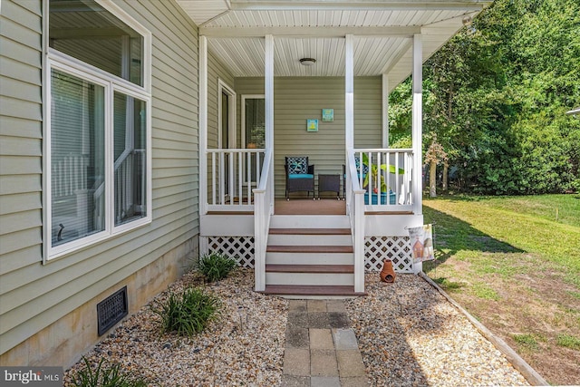 property entrance featuring a porch, a lawn, and crawl space