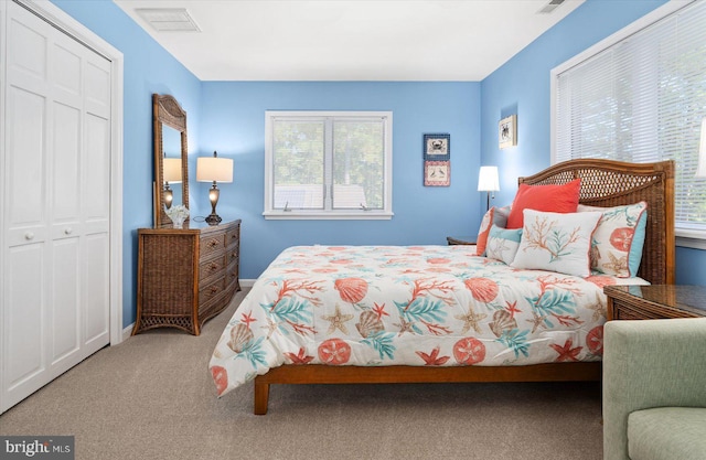 bedroom featuring a closet, baseboards, visible vents, and carpet flooring