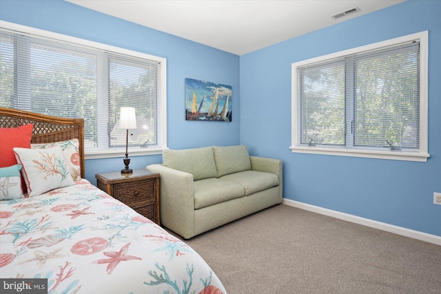 bedroom featuring multiple windows, baseboards, visible vents, and carpet floors