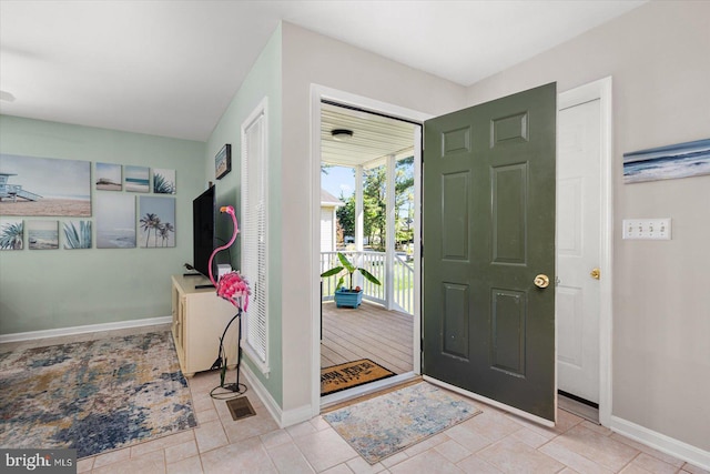 foyer featuring tile patterned floors and baseboards