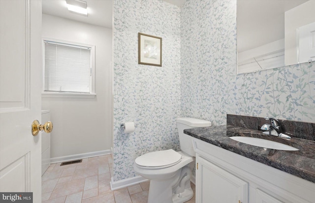 bathroom with vanity, visible vents, baseboards, wallpapered walls, and toilet