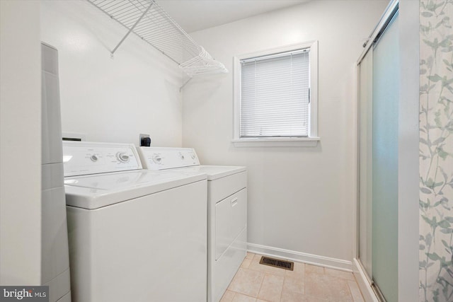 laundry room with light tile patterned floors and washing machine and dryer