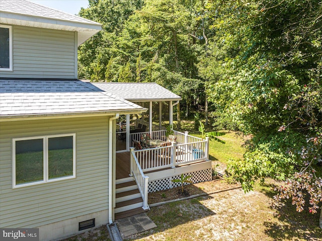 view of yard featuring a wooden deck and a sunroom