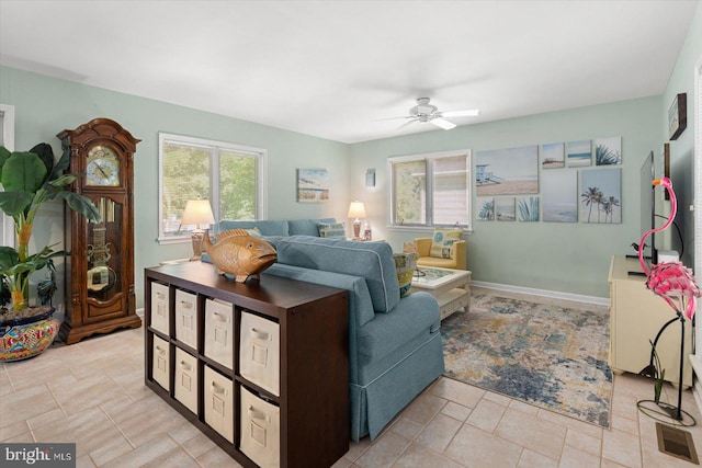 living area with visible vents, baseboards, and a ceiling fan