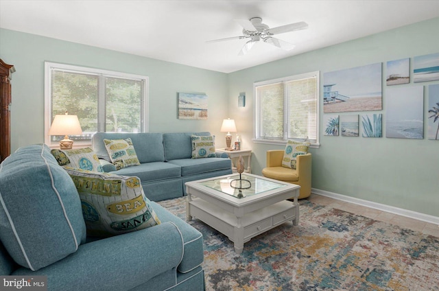 living room featuring tile patterned floors, a ceiling fan, and baseboards