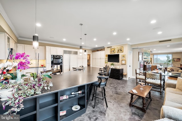 kitchen with open floor plan, ornamental molding, a sink, visible vents, and dobule oven black