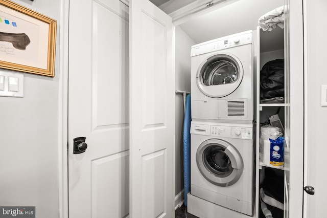 washroom featuring stacked washer / dryer and laundry area