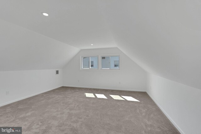 additional living space featuring light carpet and lofted ceiling