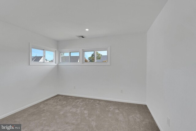 spare room featuring light colored carpet and plenty of natural light