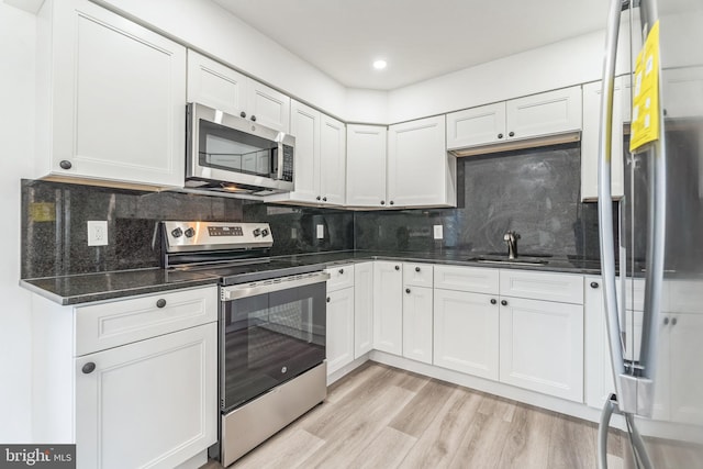 kitchen featuring white cabinetry, light hardwood / wood-style floors, and appliances with stainless steel finishes