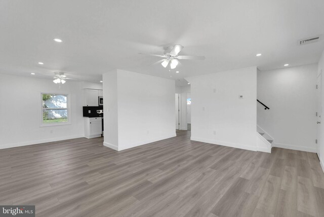 unfurnished living room featuring light wood-type flooring and ceiling fan