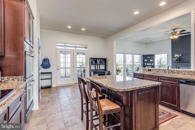 kitchen featuring a kitchen bar, plenty of natural light, a kitchen island, and stainless steel appliances