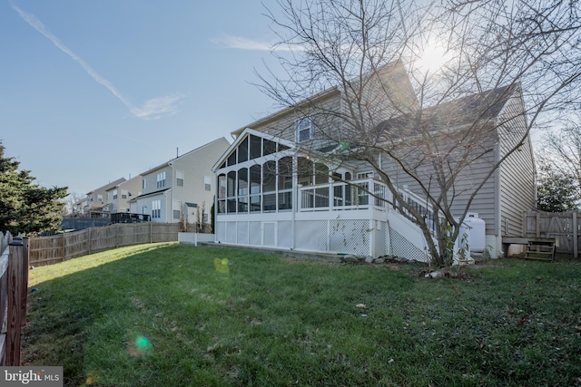 back of house with a sunroom and a yard