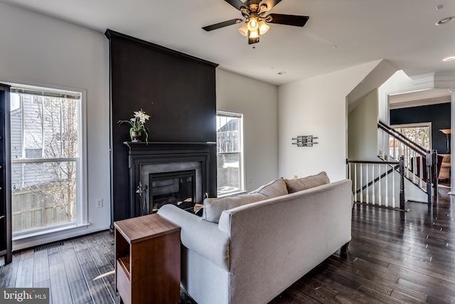 living room with dark hardwood / wood-style flooring and ceiling fan