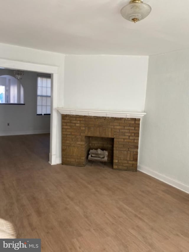 unfurnished living room featuring dark hardwood / wood-style flooring and a fireplace