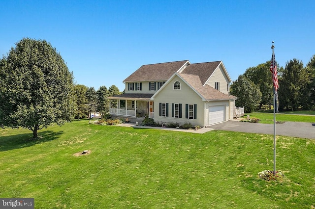 view of front of home featuring a garage, a front yard, and a porch