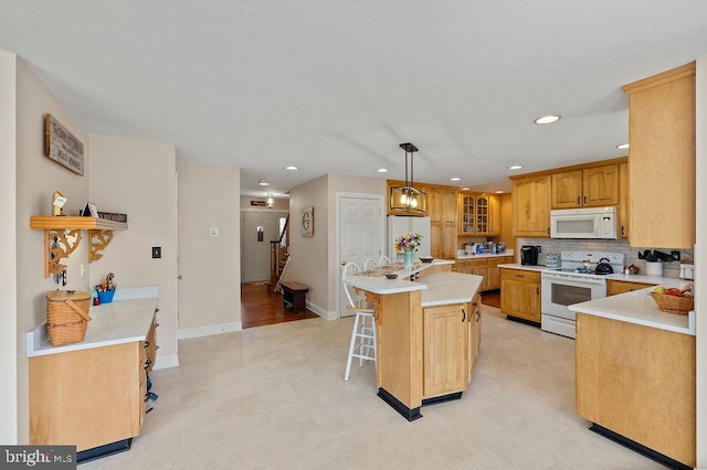 kitchen featuring backsplash, white appliances, pendant lighting, a kitchen island, and a breakfast bar