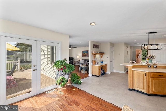 interior space with pendant lighting, ceiling fan, and light hardwood / wood-style flooring