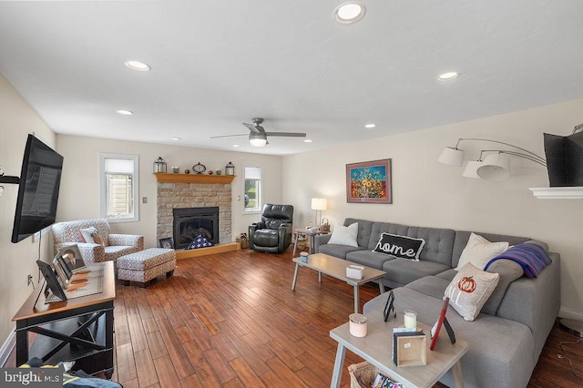 living room featuring a fireplace, hardwood / wood-style floors, and ceiling fan