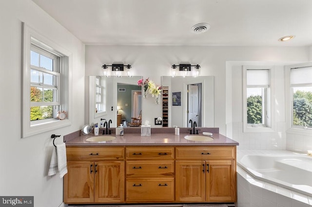 bathroom featuring vanity and a relaxing tiled tub