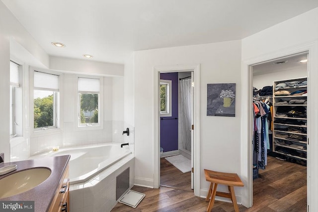 bathroom featuring wood-type flooring, separate shower and tub, and vanity