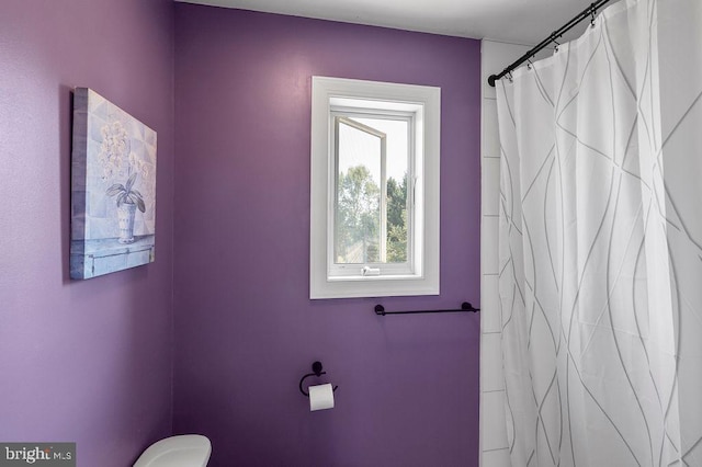 bathroom featuring a shower with shower curtain and toilet