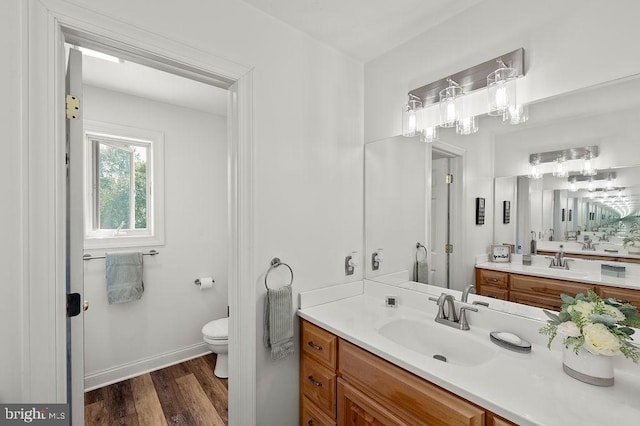 bathroom with vanity, toilet, and hardwood / wood-style floors