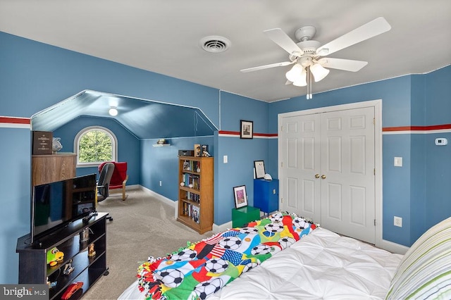 bedroom featuring a closet, ceiling fan, light colored carpet, and vaulted ceiling