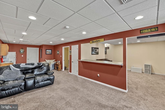 carpeted living room with indoor bar and a drop ceiling