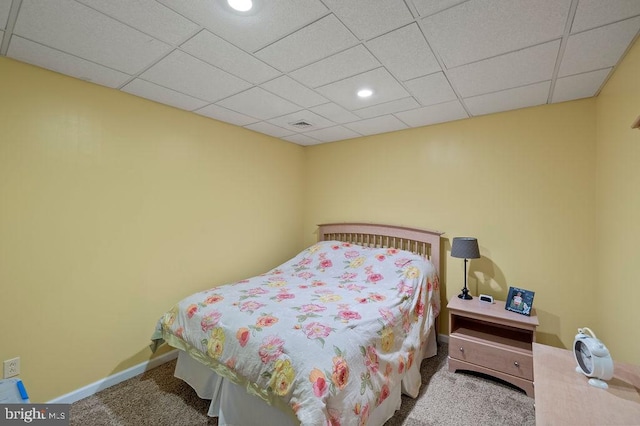 carpeted bedroom with a drop ceiling