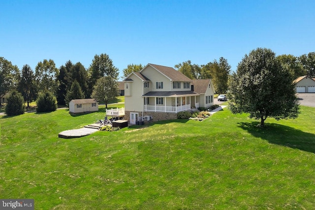 rear view of house featuring an outdoor structure and a lawn