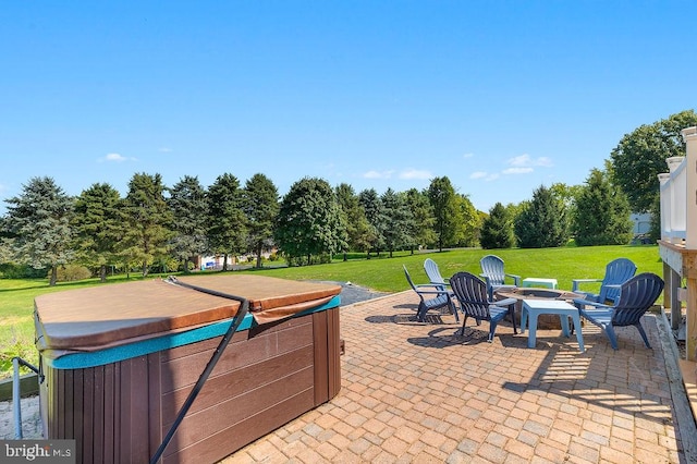 view of patio / terrace with a fire pit and a hot tub