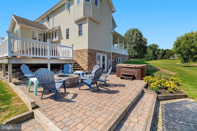 view of patio with a fire pit, a hot tub, and a wooden deck