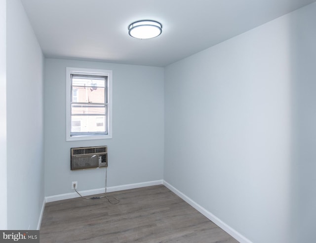 empty room featuring hardwood / wood-style flooring and a wall mounted air conditioner