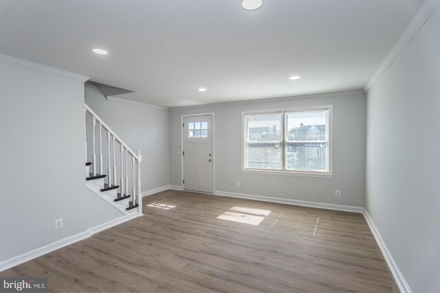 entrance foyer with ornamental molding and light hardwood / wood-style flooring