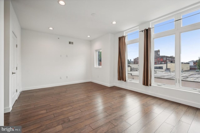 unfurnished room with dark hardwood / wood-style flooring