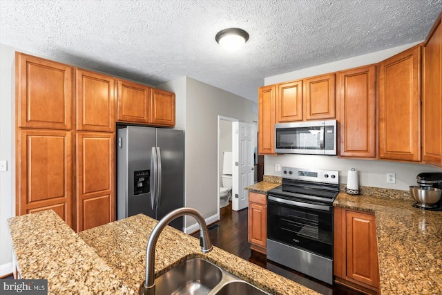 6330 Kleineidam Way, Spotsylvania, VA 22551 - kitchen with appliances with stainless steel finishes, brown cabinetry, dark wood-style flooring, and a sink