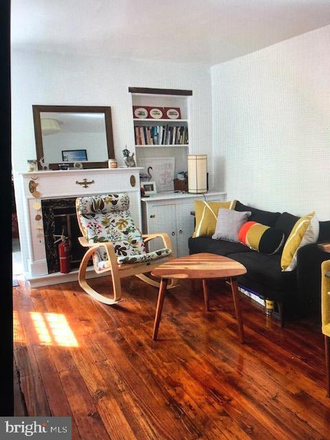 living room featuring a high end fireplace and hardwood / wood-style floors