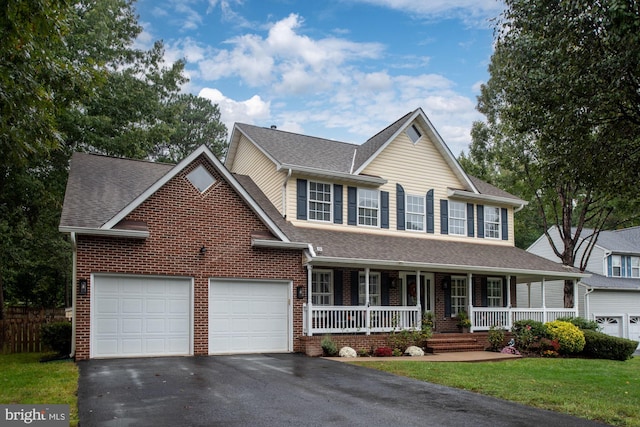 view of front facade featuring a front lawn, covered porch, and a garage