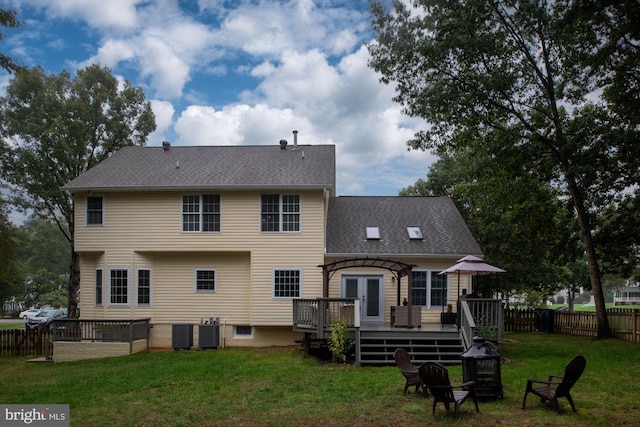 rear view of house with a lawn, central AC, and a deck