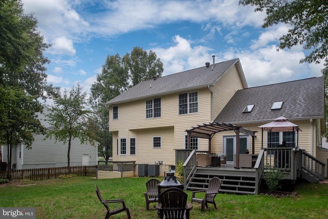 back of house featuring a lawn, a pergola, and a deck