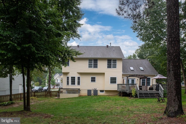 rear view of property featuring a wooden deck and a yard