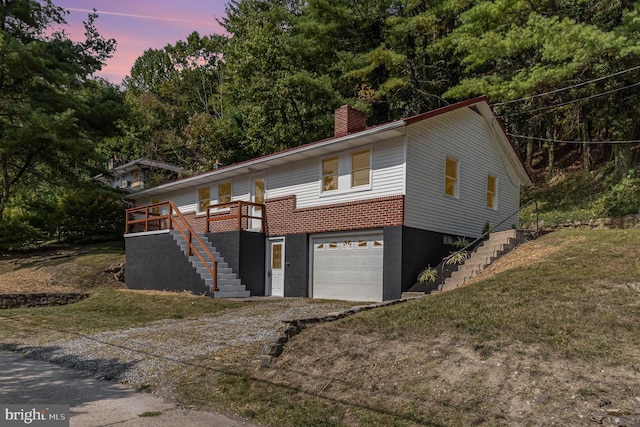 view of front of house featuring a lawn, a wooden deck, and a garage