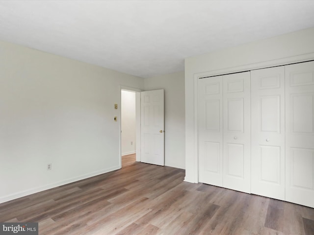 unfurnished bedroom with a closet and hardwood / wood-style floors