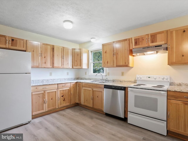 kitchen with light wood-type flooring, a textured ceiling, white appliances, and light stone countertops