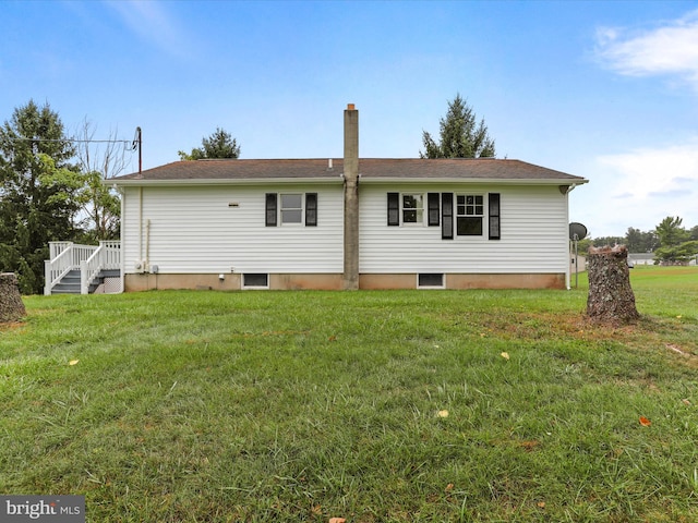 rear view of house featuring a lawn