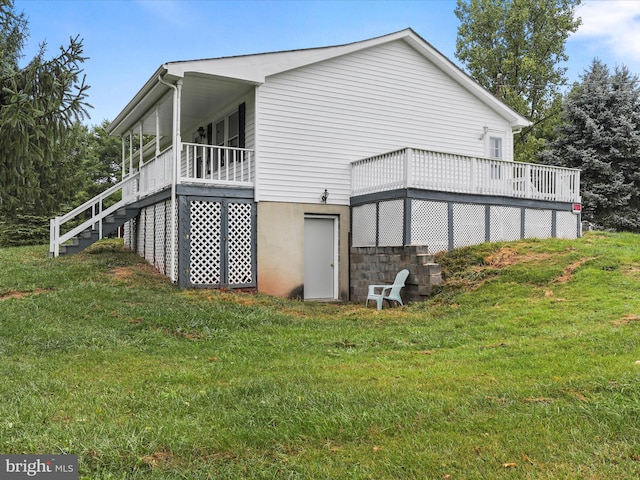 view of home's exterior with a wooden deck and a lawn